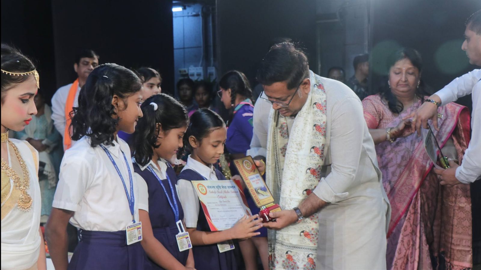 A student receiving an Award of Honour certificate and trophy from the chief guest at the Sankalp Srishti Medha Samman ceremony.
