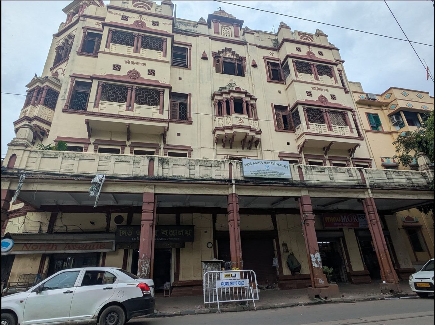 The facade of Rani Birla Bhavan on Bidhan Sarani, home to Arya Kanya Mahavidyalaya, with its ornamented cream and terracotta frontage.